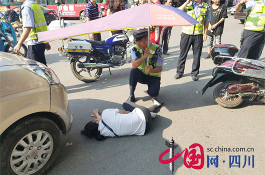 女子遭车祸倒地昏迷不醒 烈日下南充交警跪地为其撑伞