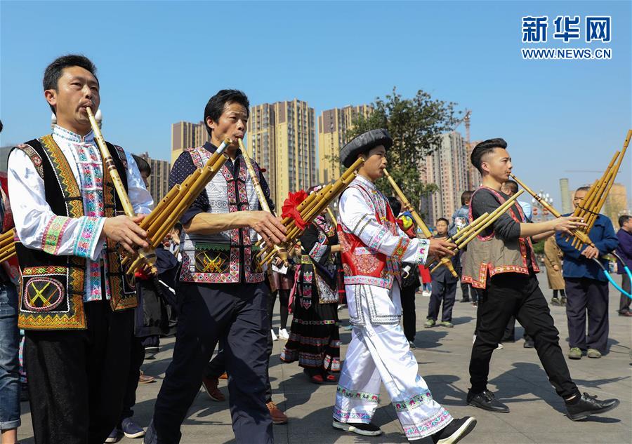 4月1日,在四川省兴文县市民广场,苗族群众在活动中吹芦笙.