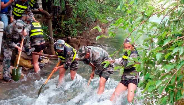 面对诺日朗瀑布再次坍塌的险情 民兵突击队跳入水中疏通河道